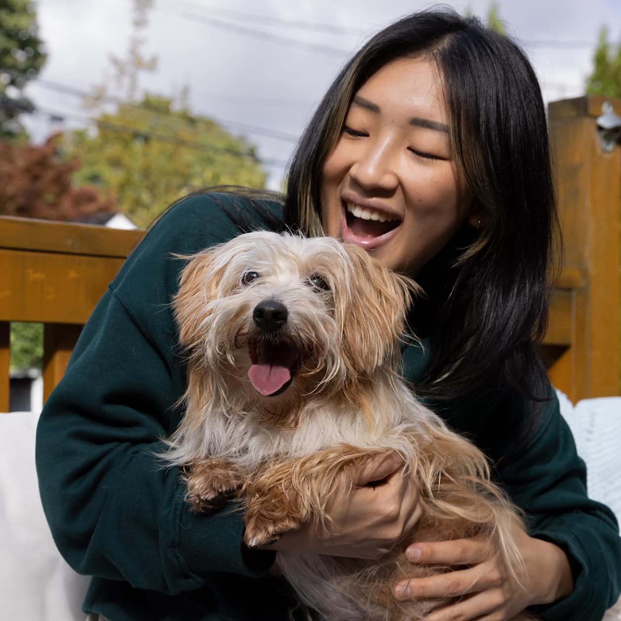 Uma mulher com um cachorrinho feliz nos braços