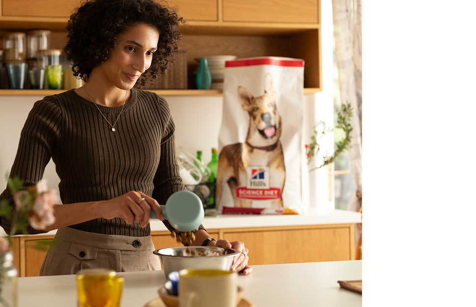 Uma mulher servindo alimento Hill´s em uma tigela