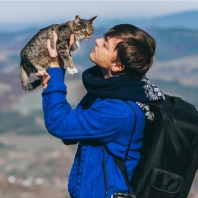 Um homem em uma caminhada segurando um gato
